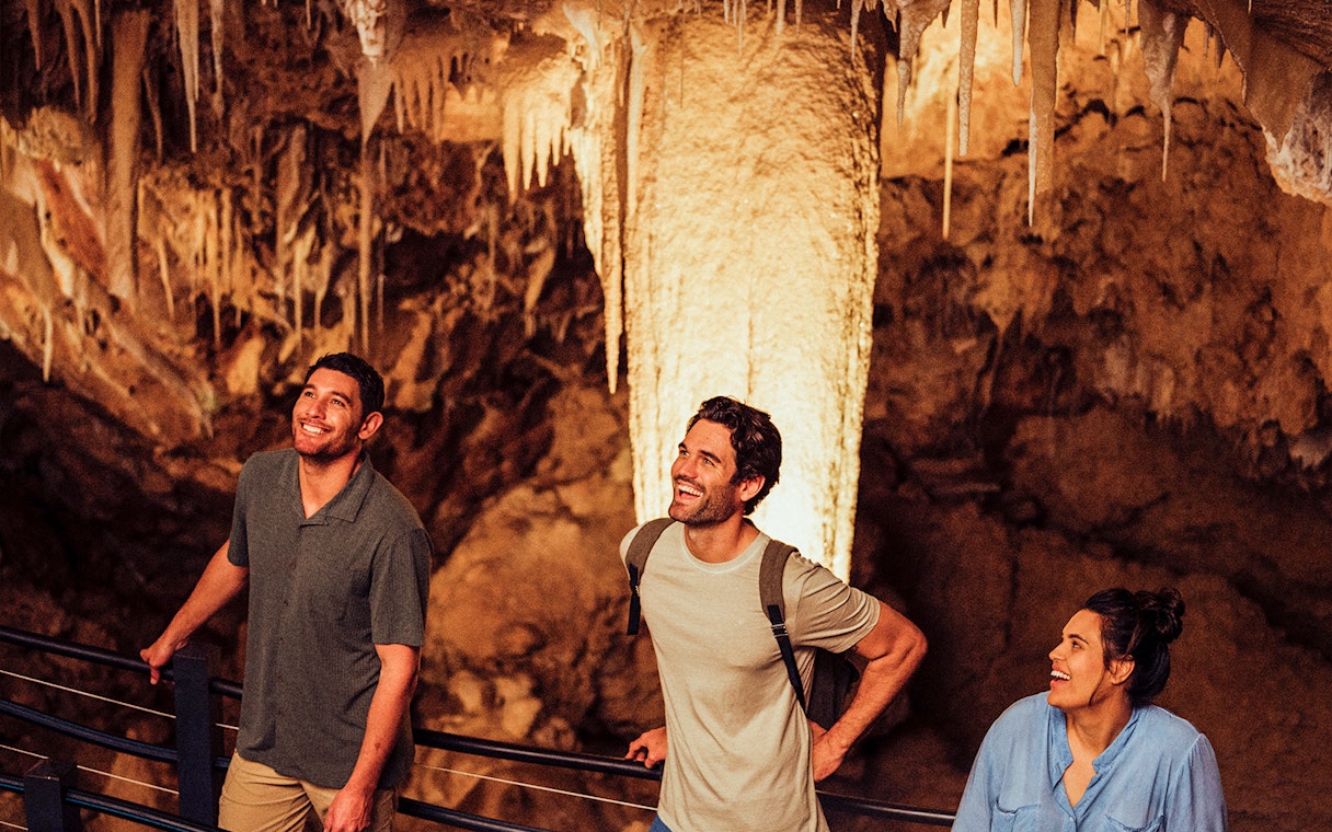 Visitors exploring stalactites in Ngilgi Cave, Australia.