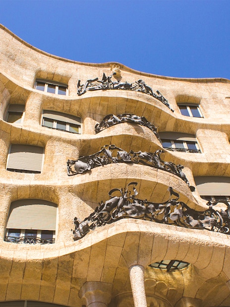 Casa Mila Rooftop with unique chimneys and Barcelona cityscape in the background.