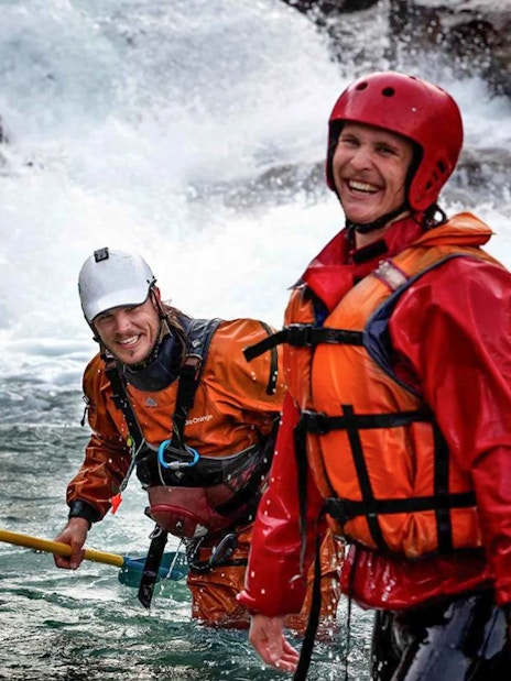 Rafters in gear smiling on Shotover River, Queenstown, during a whitewater rafting adventure.