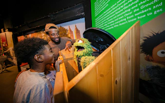 Guests interacting with a puppet exhibit inside RiseNY.