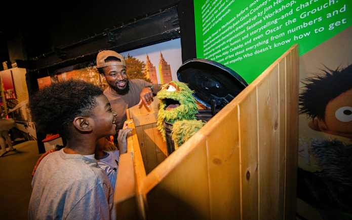 Guests interacting with a puppet exhibit inside RiseNY.