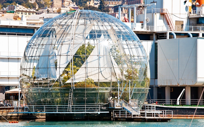 Genoa Aquarium Biosphere glass dome with plants inside, located by the waterfront.