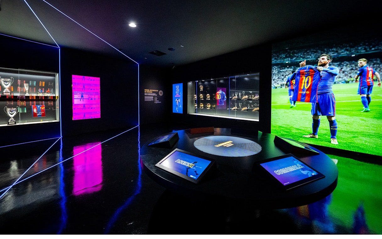 Camp Nou Barca Museum exhibit with trophies and player memorabilia.