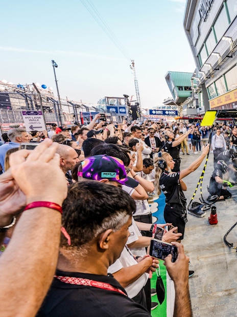 Crowd watching a Formula 1 pit crew during an exclusive Pit Lane Walk.