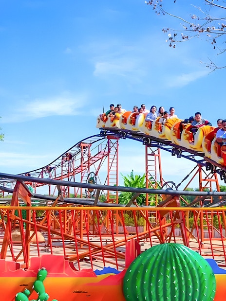 Roller coaster with passengers at Dream World Bangkok.