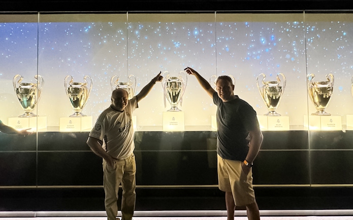 Visitors with trophies at Santiago Bernabeu Stadium tour.