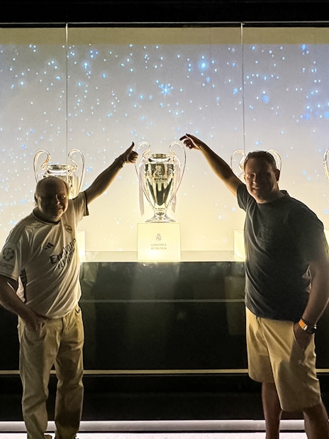 Visitors with trophies at Santiago Bernabeu Stadium tour.