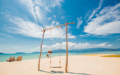 Swing on sandy beach at Koh Samui Pig Island with ocean view.