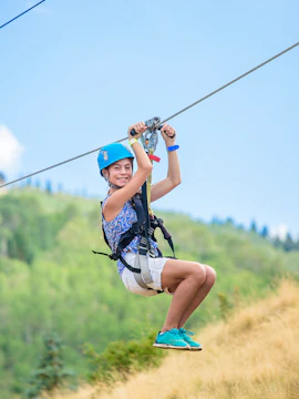 Person ziplining at Mega Adventure Singapore with lush greenery in the background.