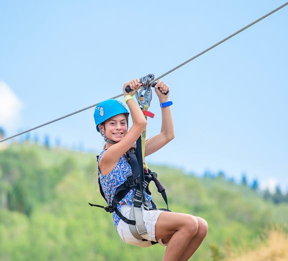 Visitors zip-lining through lush greenery at Mega Adventure Singapore, Sentosa Island.