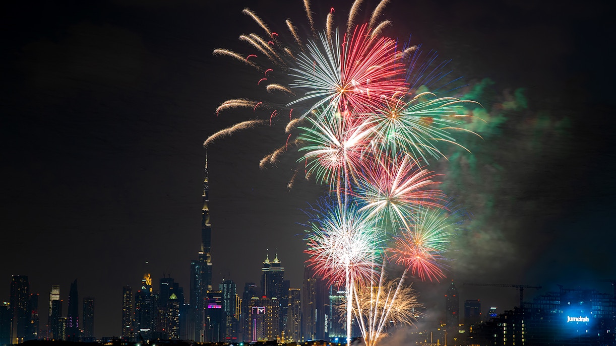 Dubai skyline with colorful New Year 2024 fireworks display.