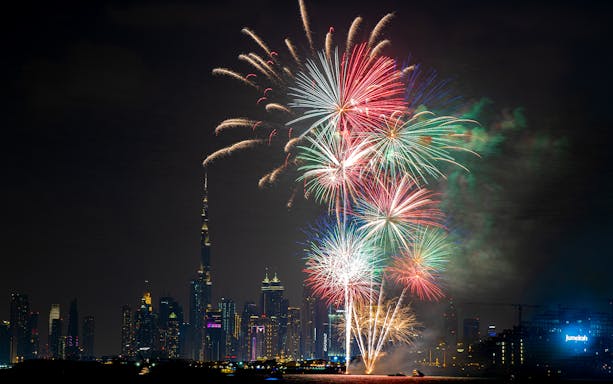 Dubai skyline with colorful New Year 2024 fireworks display.
