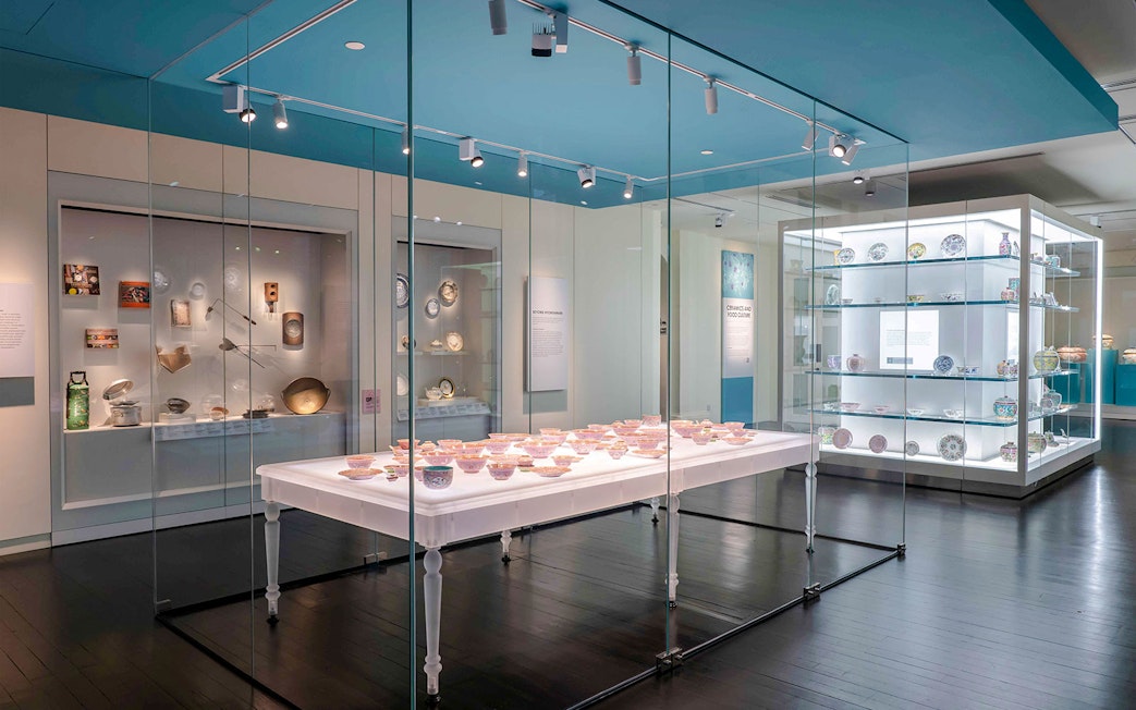 Peranakan Museum gallery displaying traditional ceramics and artifacts in glass cases.