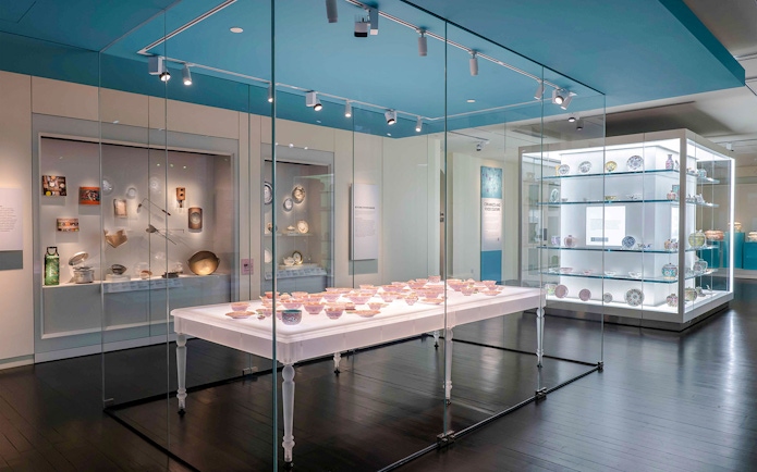 Peranakan Museum gallery displaying traditional ceramics and artifacts in glass cases.