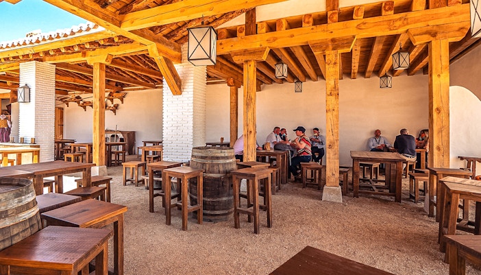 Puy du Fou Park medieval village scene with tourists enjoying food
