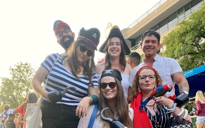 Group in pirate costumes on Boomerang Pirate Ship 21+ Party Cruise with DC monuments in background.