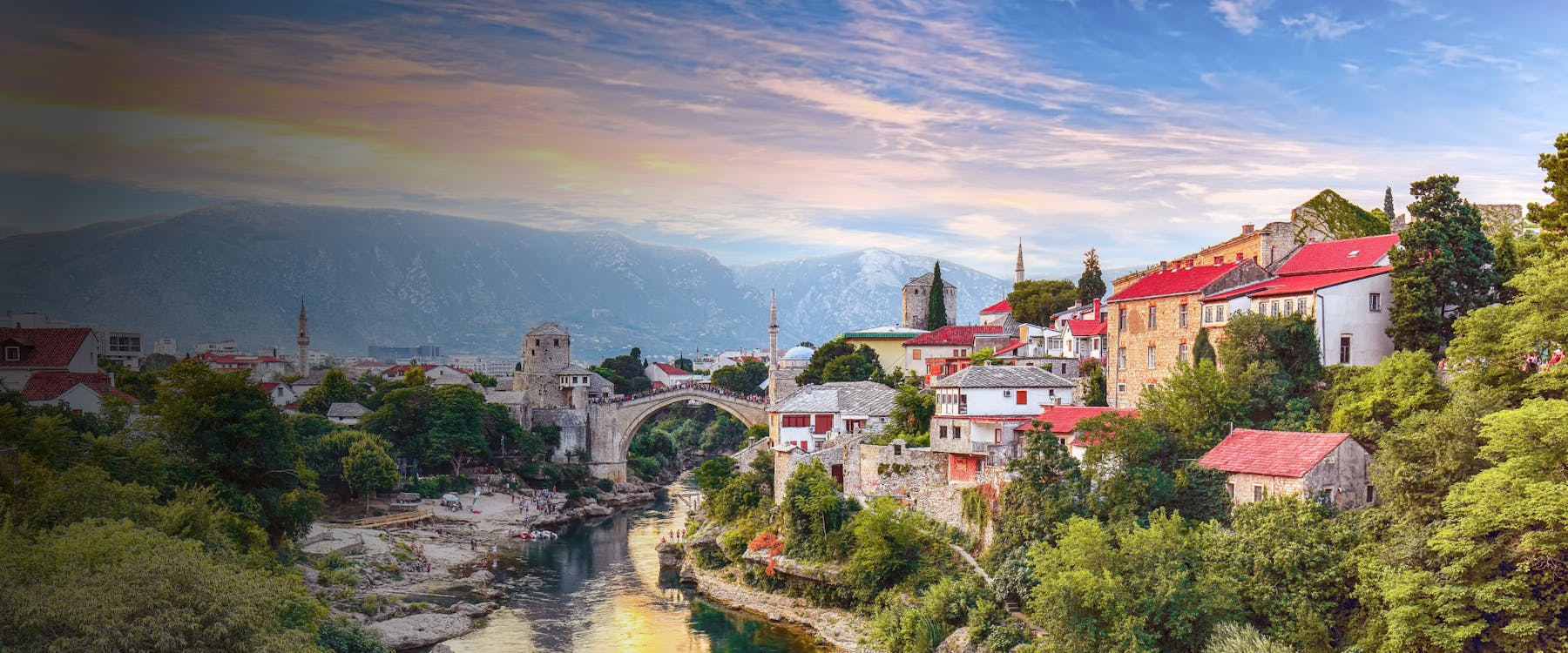 Stari Most bridge over Neretva River in Mostar, Bosnia and Herzegovina, with surrounding historic buildings.