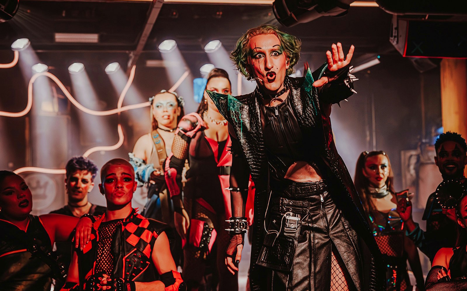 Performer on stage at "Oscar at the Crown" show with dramatic lighting and costumes.