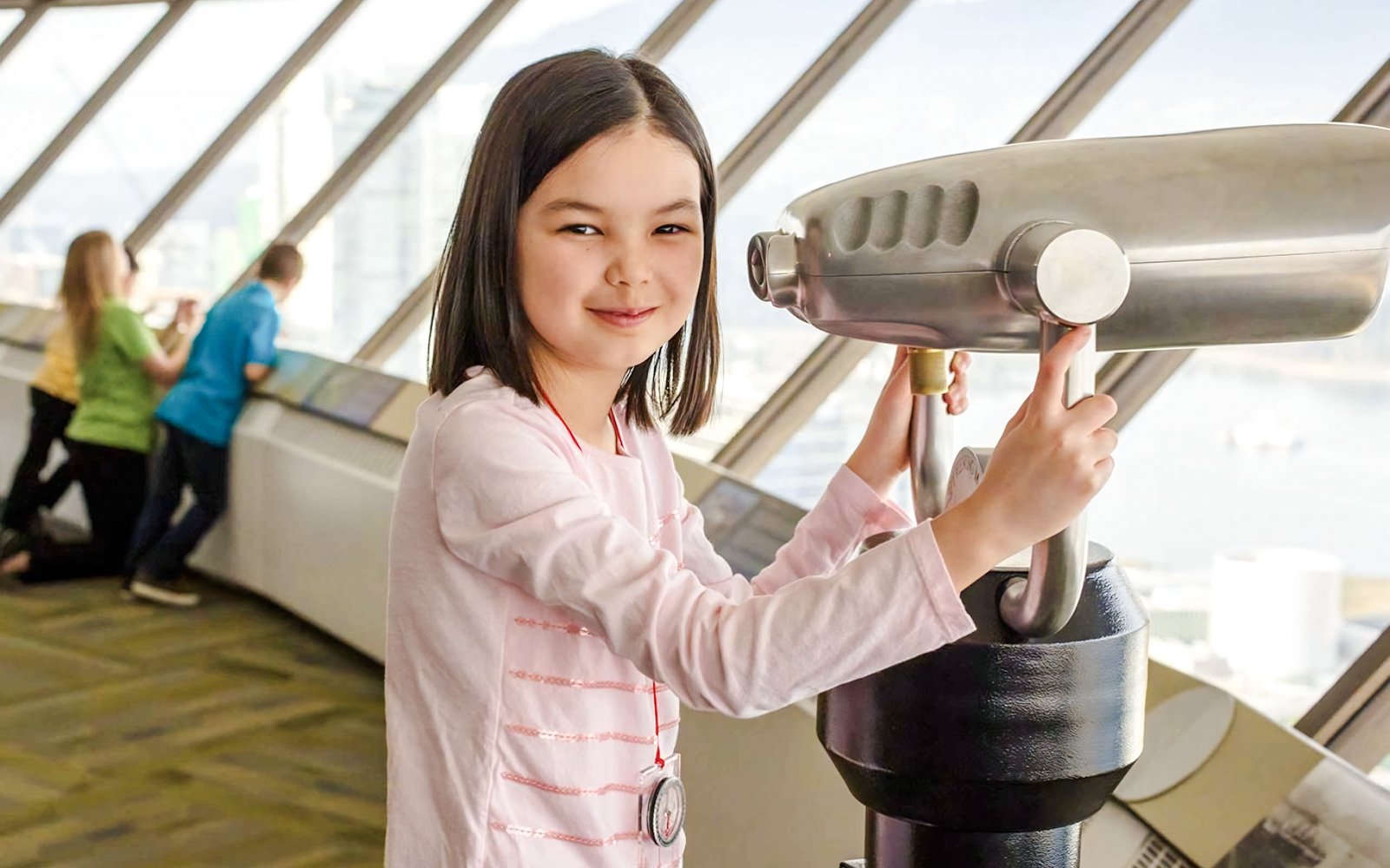 Child using a telescope at an observation deck in Vancouver, near Capilano Suspension Bridge.