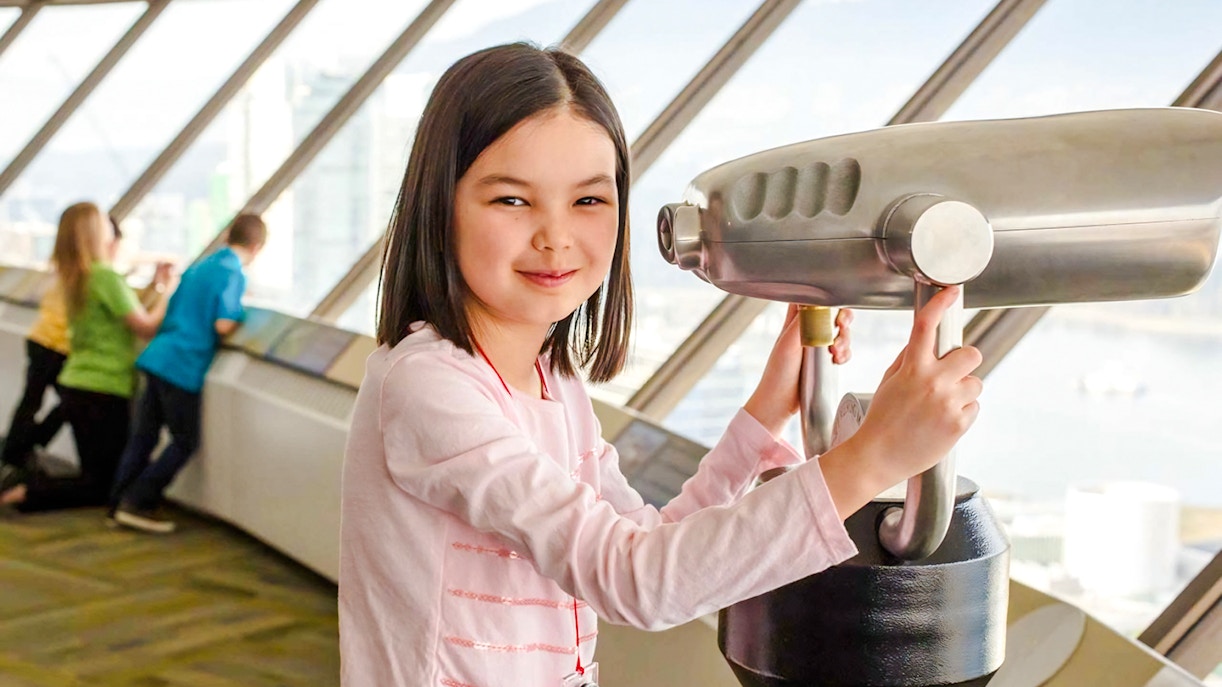 Child using a telescope at an observation deck in Vancouver, near Capilano Suspension Bridge.