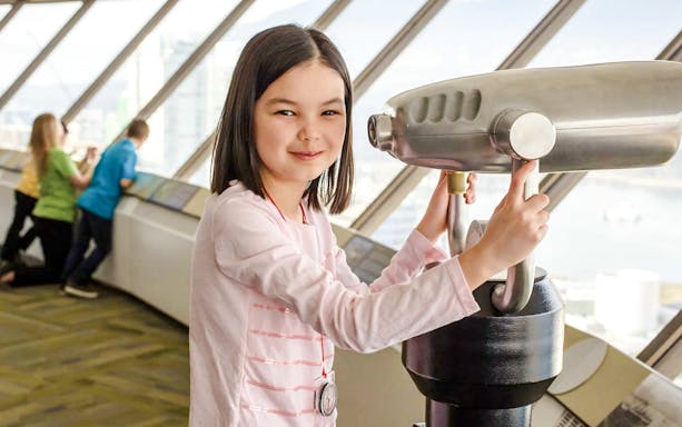 Child using a telescope at an observation deck in Vancouver, near Capilano Suspension Bridge.