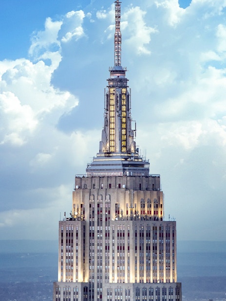 Empire State Building spire against a cloudy sky, New York City.