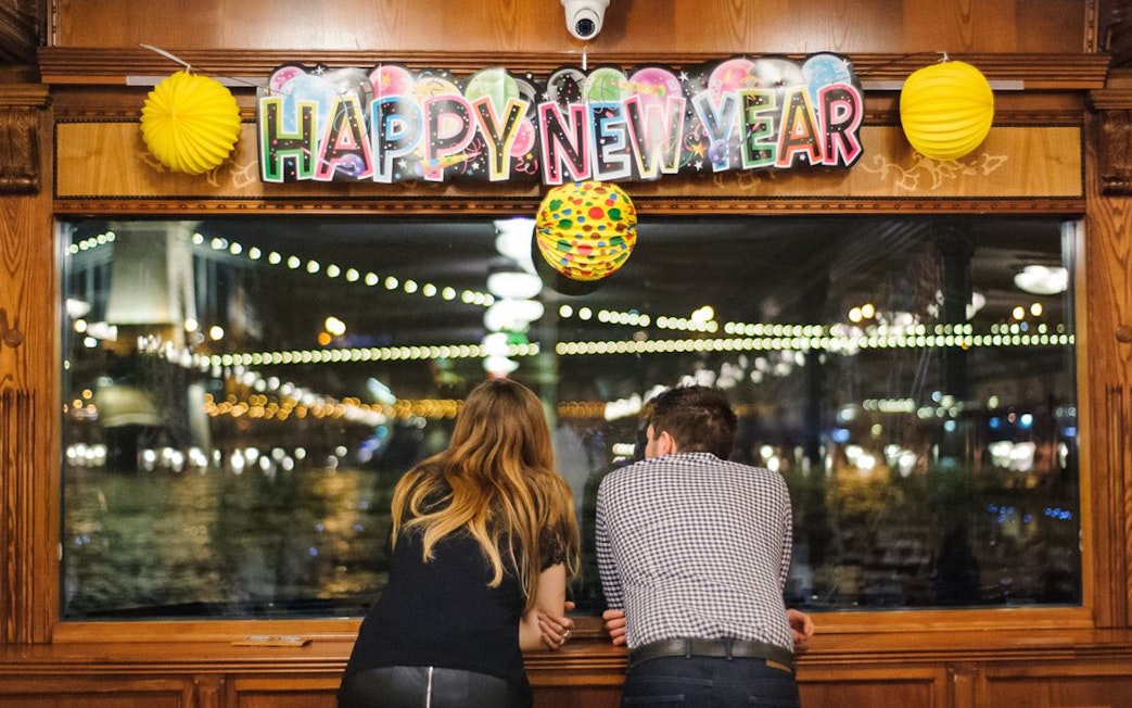 Couple enjoying New Year’s Eve cruise view in Budapest with festive decorations.