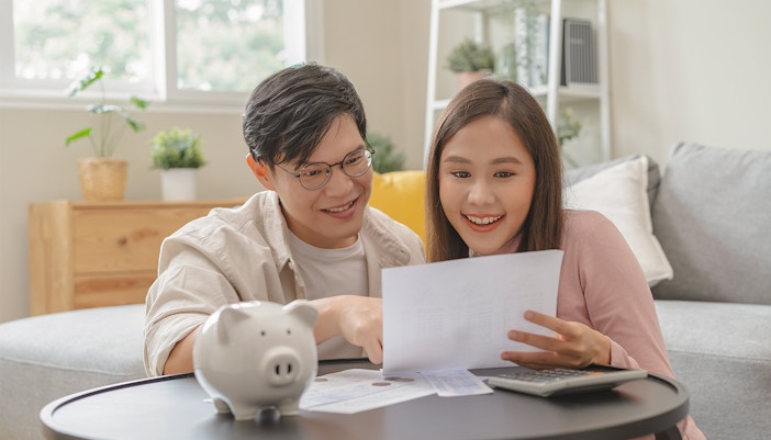 Couple reviewing savings with piggy bank