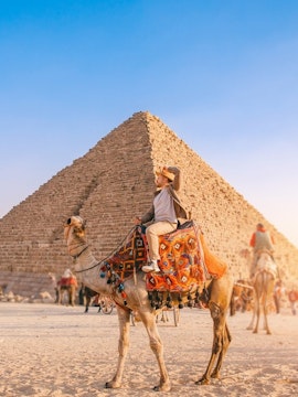 Camel ride in front of the Pyramid of Khafre at the Giza Complex, Egypt.