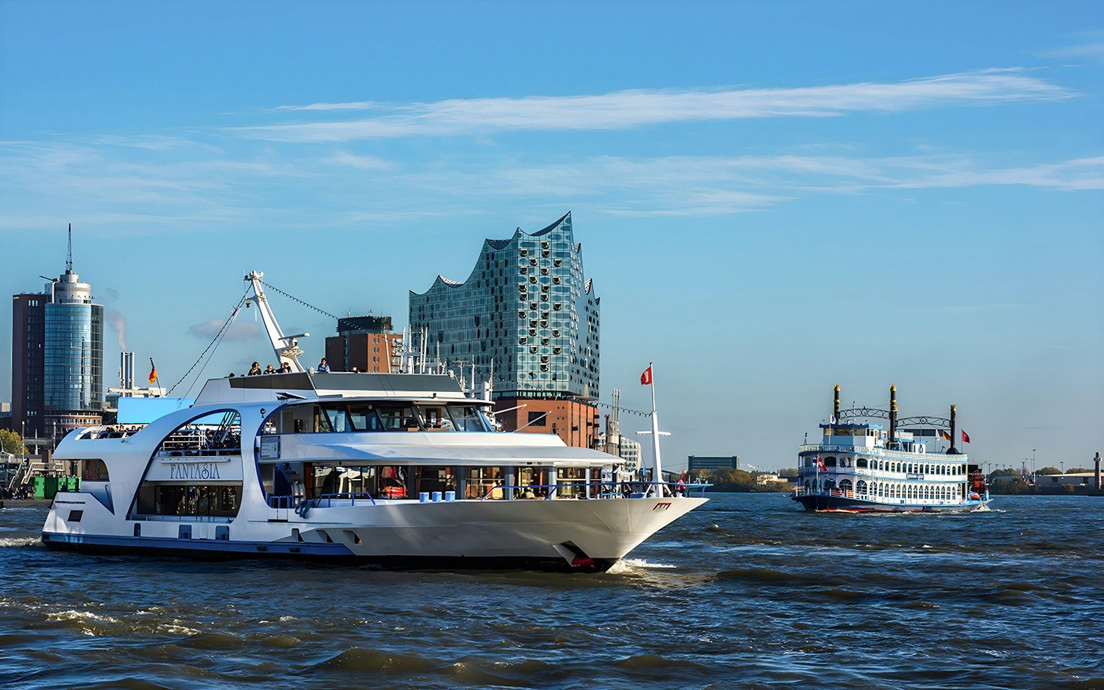 Cruise boats on the Elbe River with Elbphilharmonie in Hamburg.