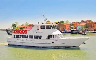 Boat cruising near colorful buildings in Burano, Venice, during afternoon tour from Punta Sabbioni.