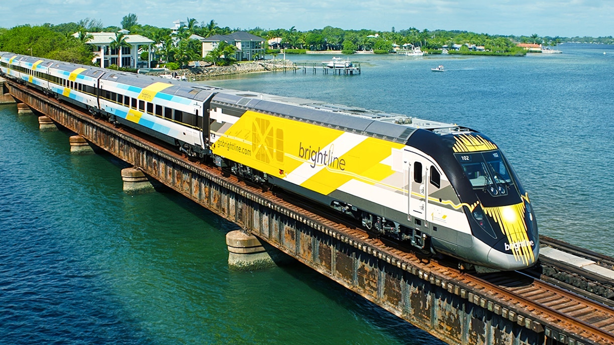 Brightline train crossing a bridge over water, Miami to Orlando route.