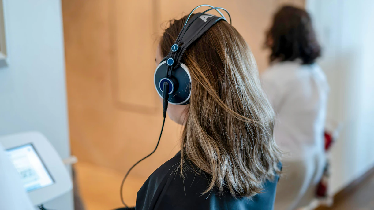 Visitor using audio guide at Oceanographic Museum exhibit.