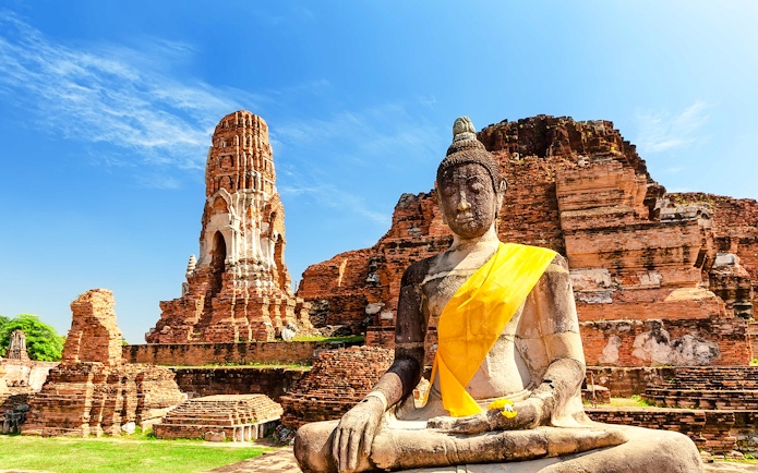 Buddha statue and ancient temple ruins at Ayutthaya Historical Park, Thailand.