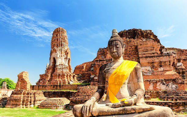 Buddha statue and ancient temple ruins at Ayutthaya Historical Park, Thailand.