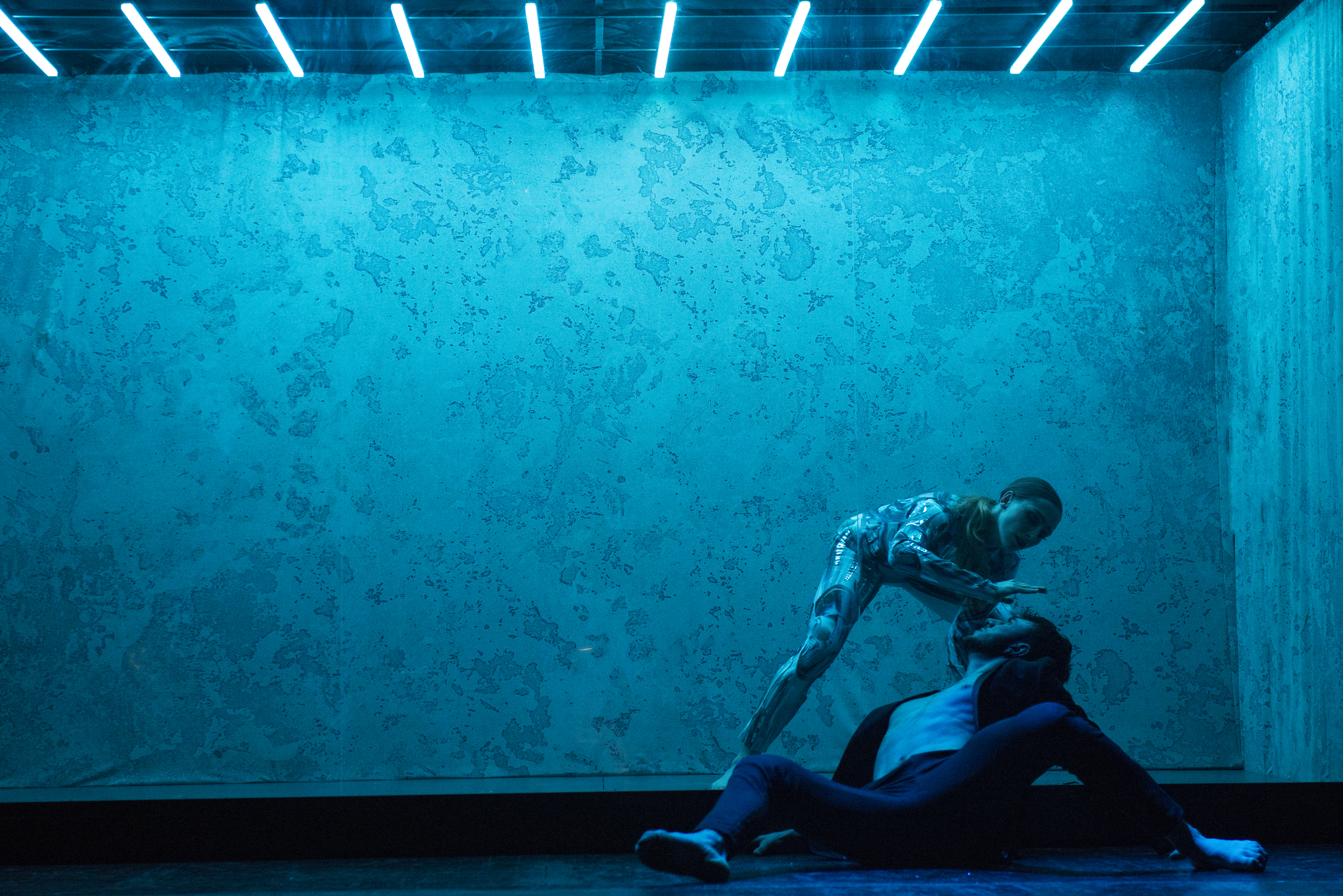 Dancers performing under blue lights at Paradis Latin festive show.