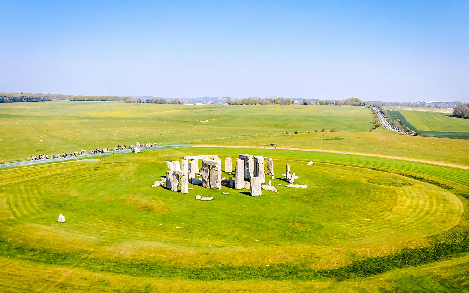 Aerial view of Stonehenge surrounded by green fields in Wiltshire, England.