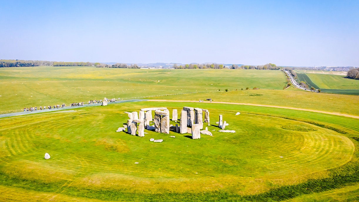 Aerial view of Stonehenge surrounded by green fields in Wiltshire, England.