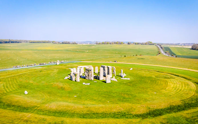 Aerial view of Stonehenge surrounded by green fields in Wiltshire, England.