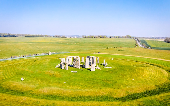 Aerial view of Stonehenge surrounded by green fields in Wiltshire, England.