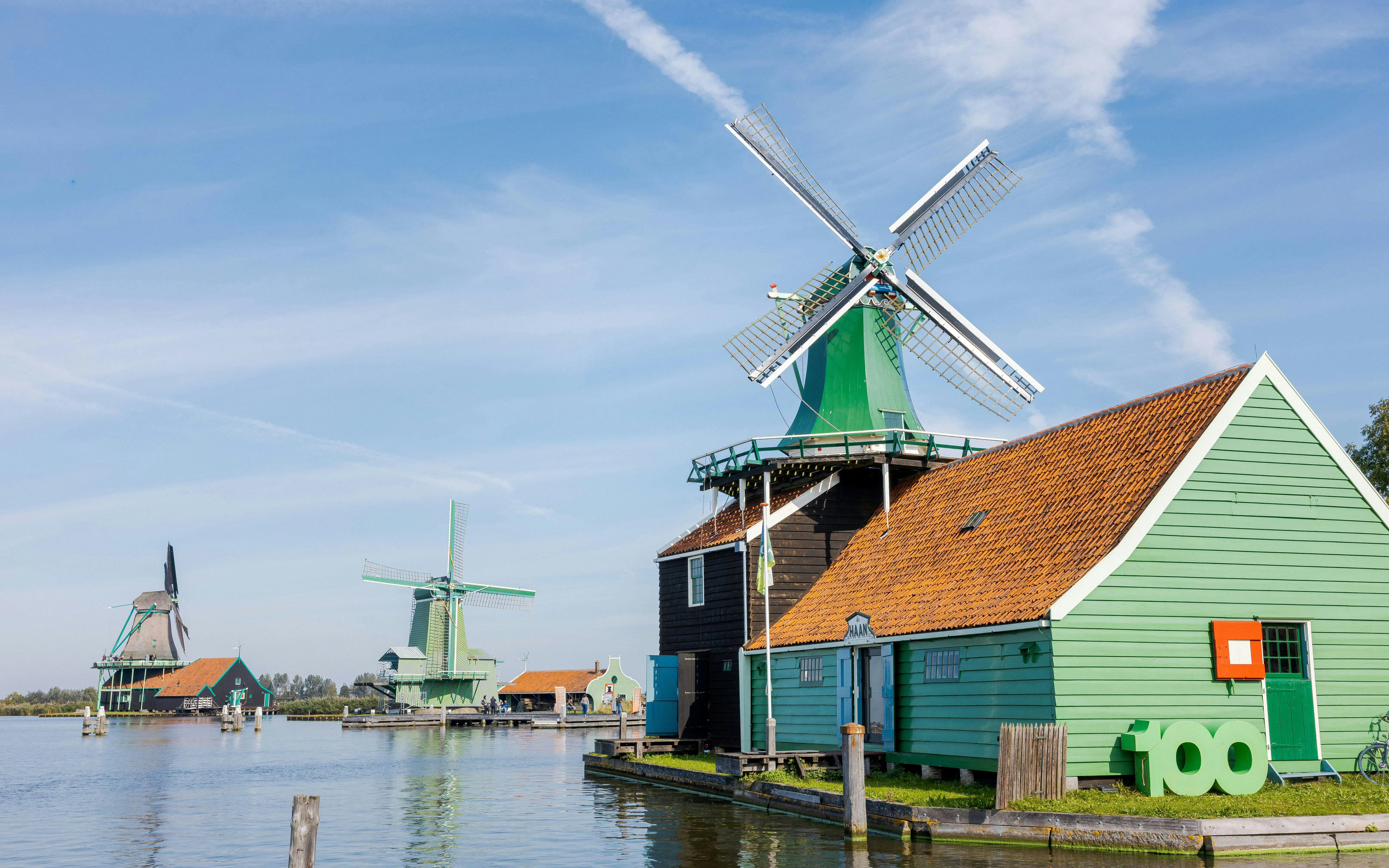 Windmills and traditional houses by the water in Zaanse Schans, Netherlands.