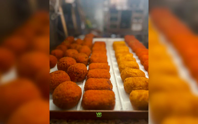 Arancini and supplì on display during a Trastevere street food tour in Rome.