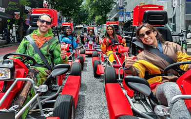Participants in costumes driving go-karts on a Shibuya street tour.