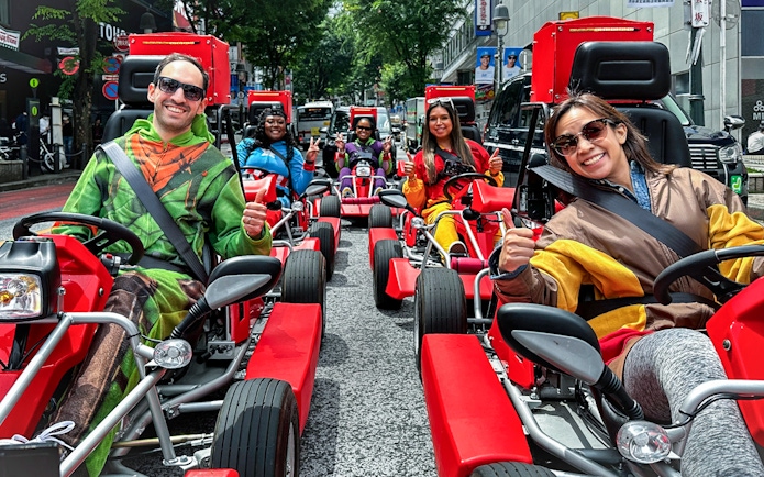Participants in costumes driving go-karts on a Shibuya street tour.