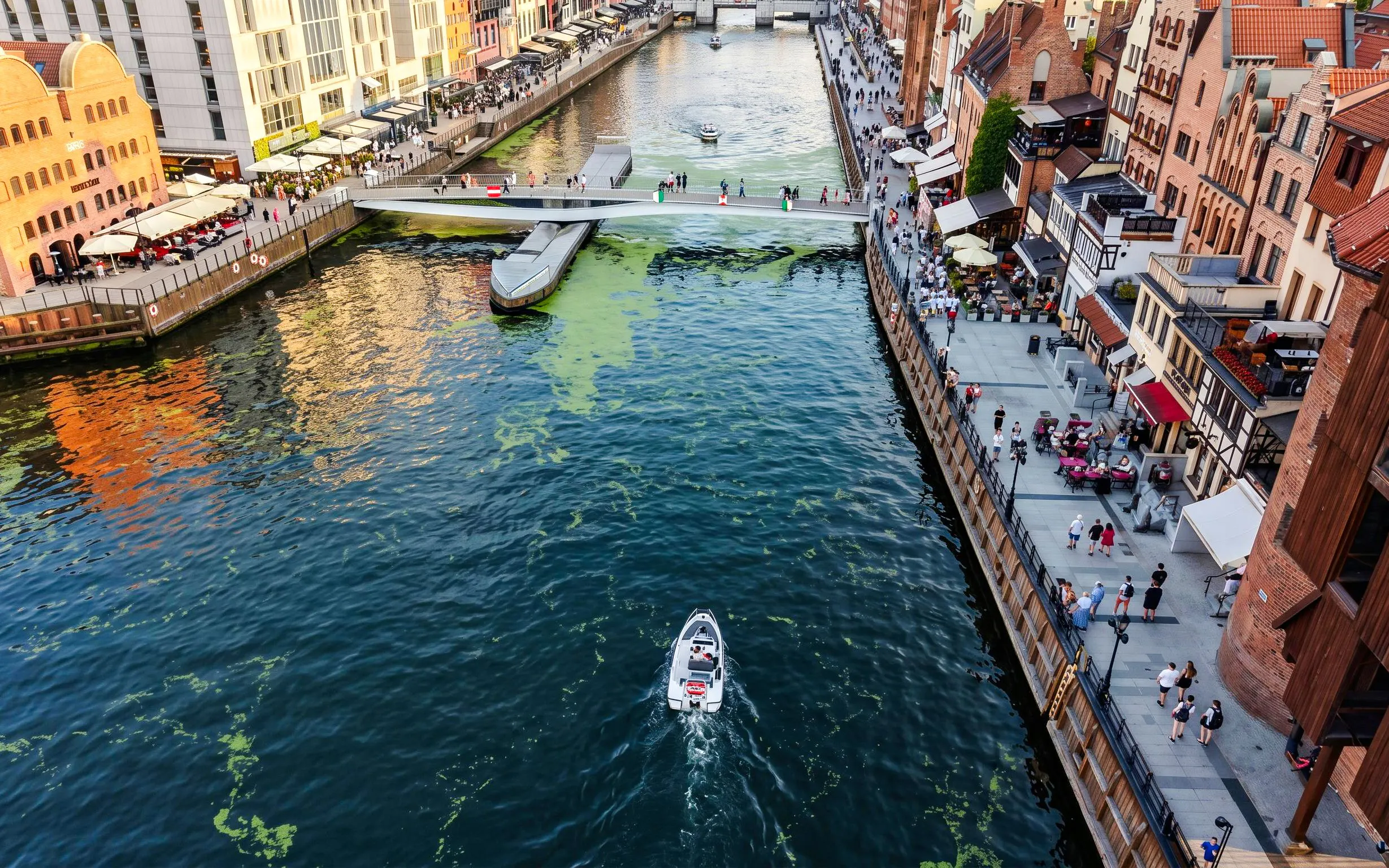 Guests navigating a self-drive electric boat on the Motława River in Gdansk.