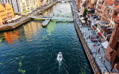 Guests navigating a self-drive electric boat on the Motława River in Gdansk.