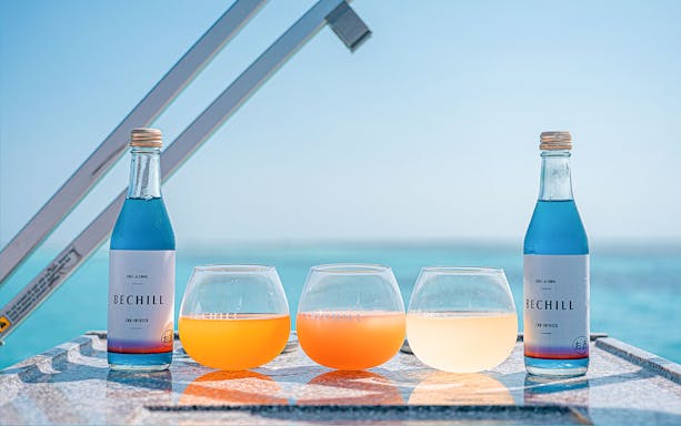 Bottles and glasses on a table with Ishigaki Island sea view in the background.