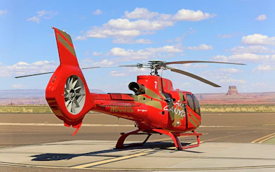 Helicopter on tarmac with desert landscape, preparing for Horseshoe Bend aerial tour.