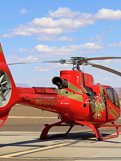 Helicopter on tarmac with desert landscape, preparing for Horseshoe Bend aerial tour.