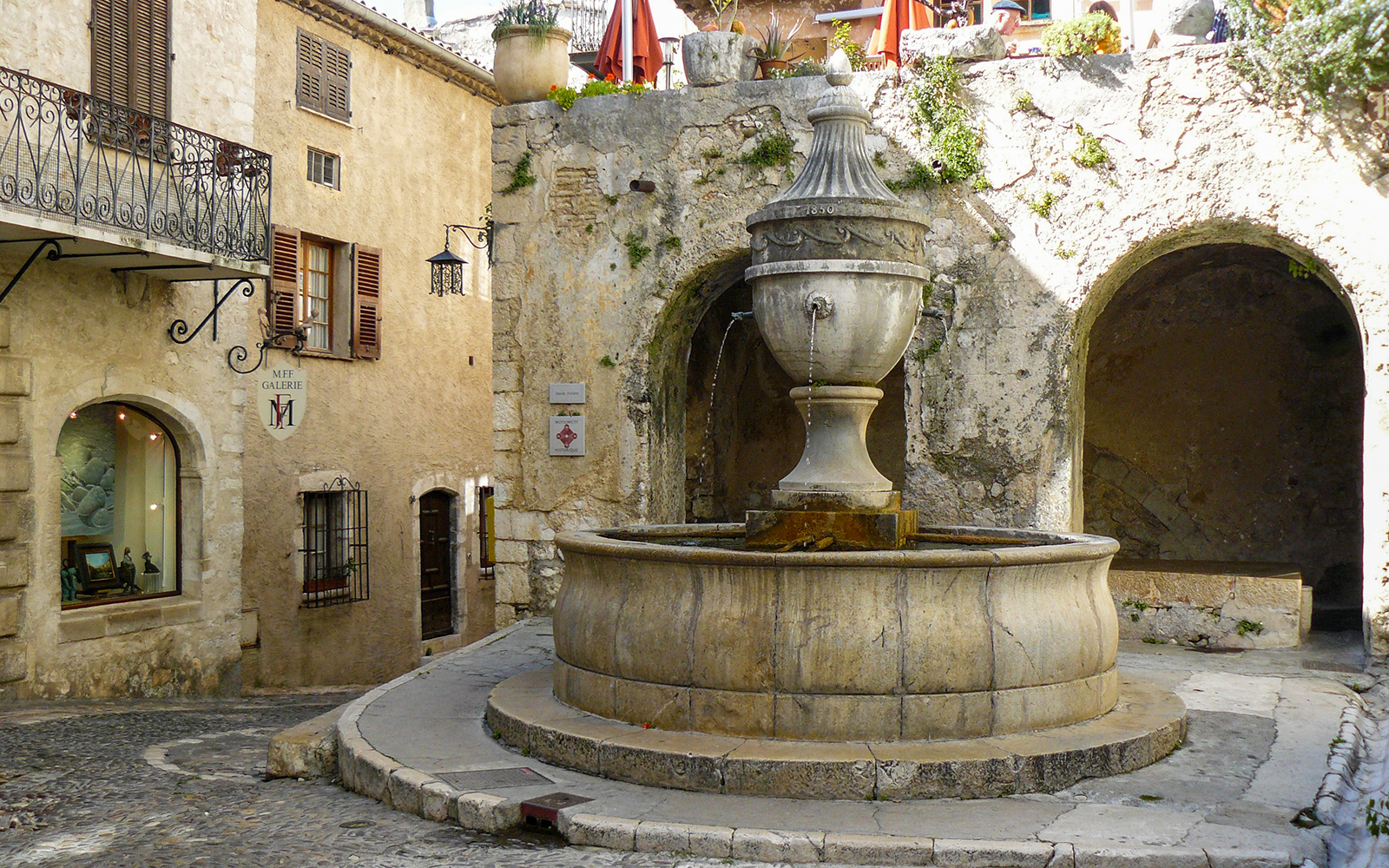 Stone fountain in a quaint street of a Provence village, France.